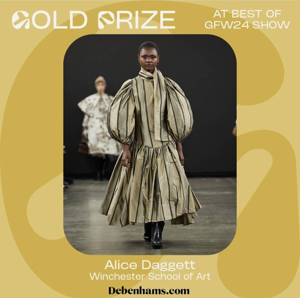 A model wearing a striped, voluminous dress walks on a runway. Text: "Gold Prize at Best of GFW24 Show, Alice Daggett, Winchester School of Art. Debenhams.com.