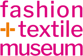 Pink text reading "fashion + textile museum" with an orange plus sign.